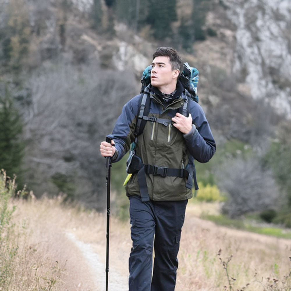 Homme avec bâton de marche léger et robuste, idéal pour la randonnée sur tous types de terrains.