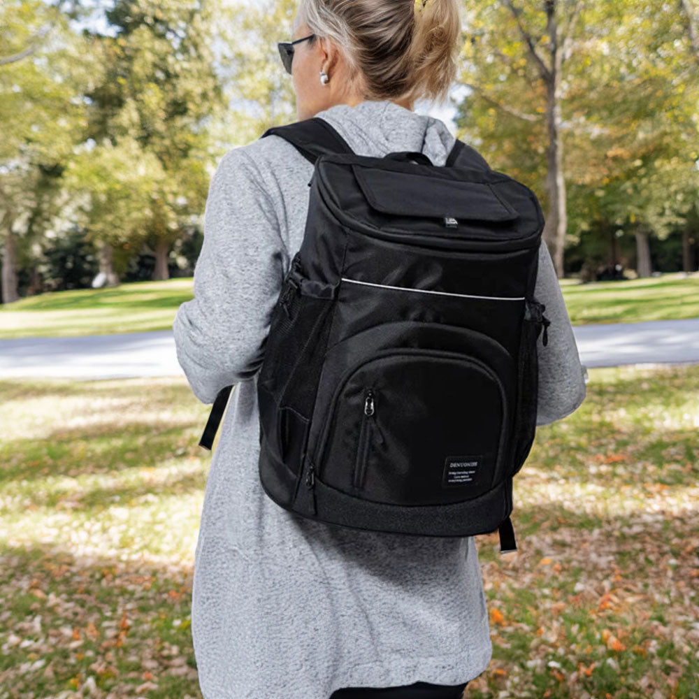 Femme portant un sac dos isotherme noir 30L spacieux et confortable, parfait pour les excursions et sorties en plein air.